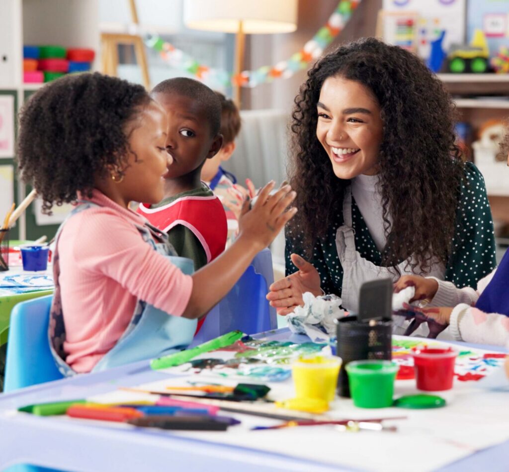 Education, children or painting with teacher in class for art, creative talent or motor skill development in preschool. Learning, students drawing or teaching happy kids for lesson or help with color
