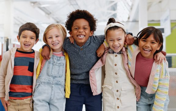Science, portrait and group of children with happiness at convention, expo or exhibition for workshop. Student, kid or face with smile at tradeshow or scientific conference for knowledge or education